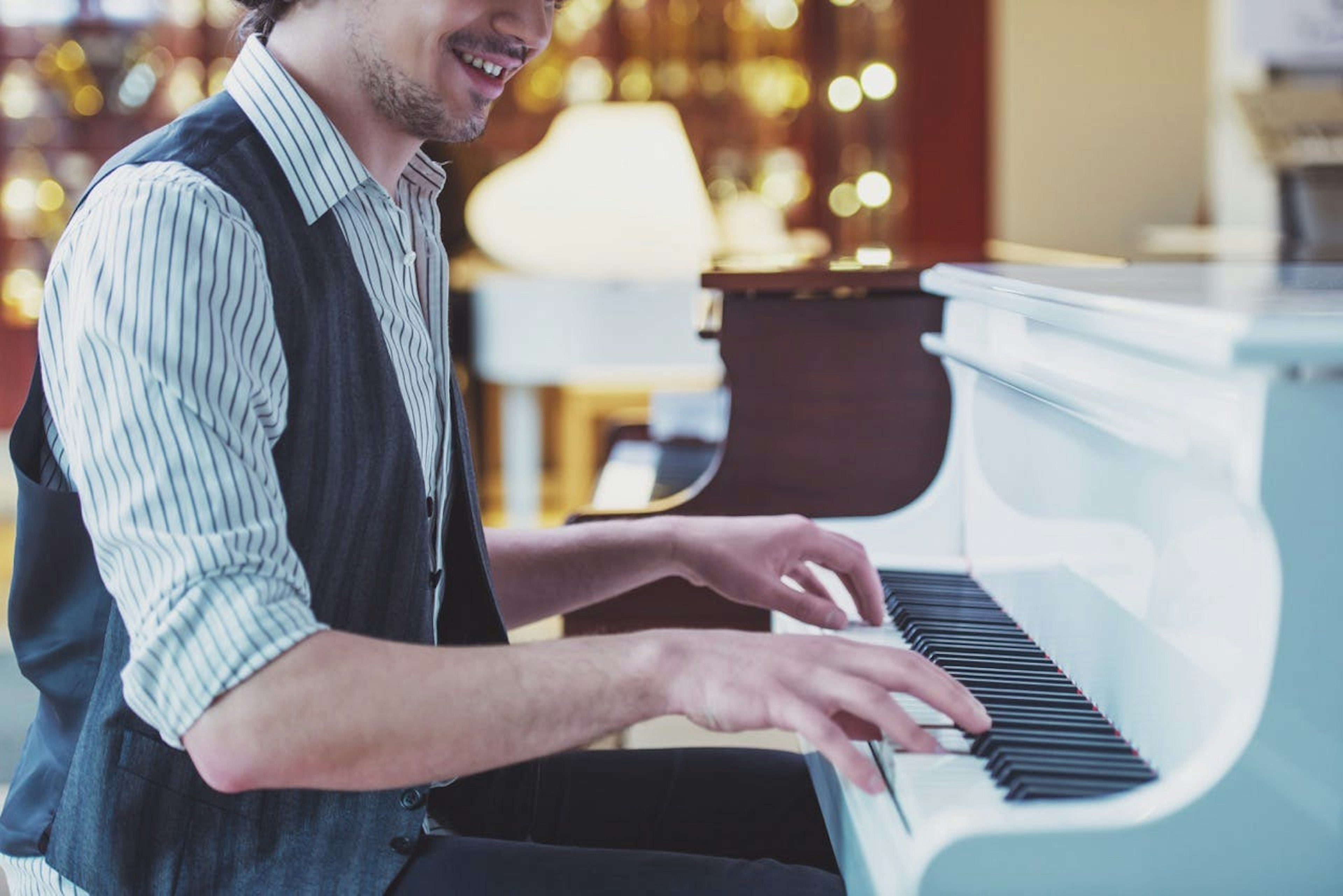 man playing white piano 